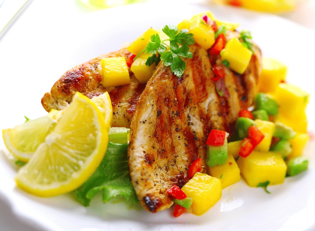 Grilled chicken with mango salsa and slices of lemon