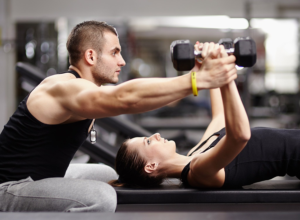 trainer and client lifting weights