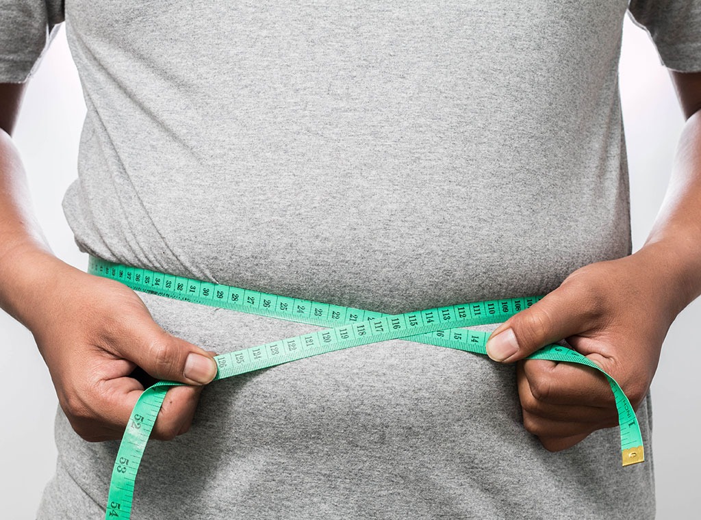 Man measuring waistline with measuring tape