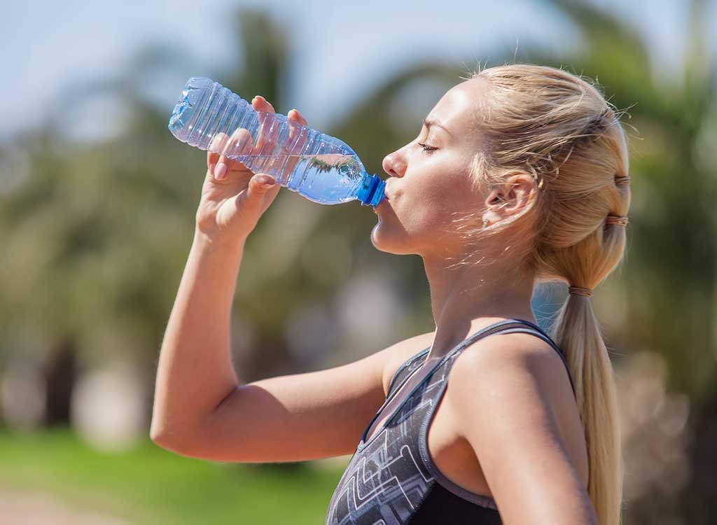 Woman drinking out of plastic water bottle