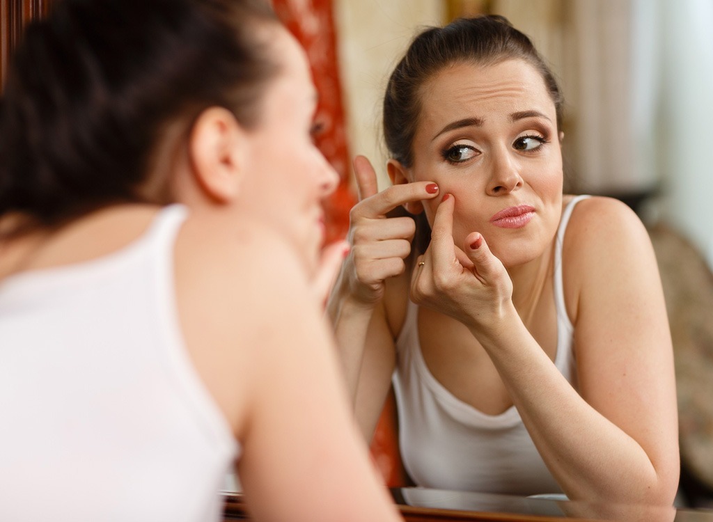 woman with acne mirror