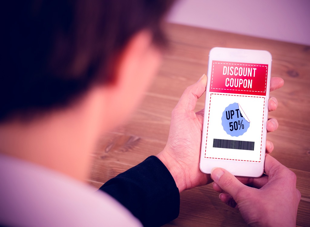 uomo che tiene il cellulare guardando i coupon