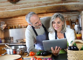 older couple cooking with tablet