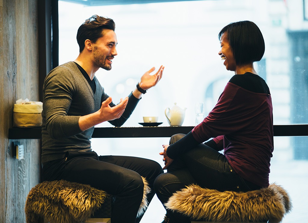 Two people having conversation at a bar