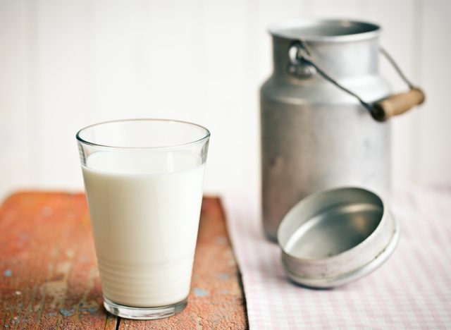 skim milk in glass next to aluminum container