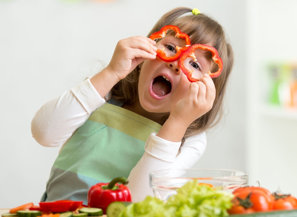 Kid playing with vegetables