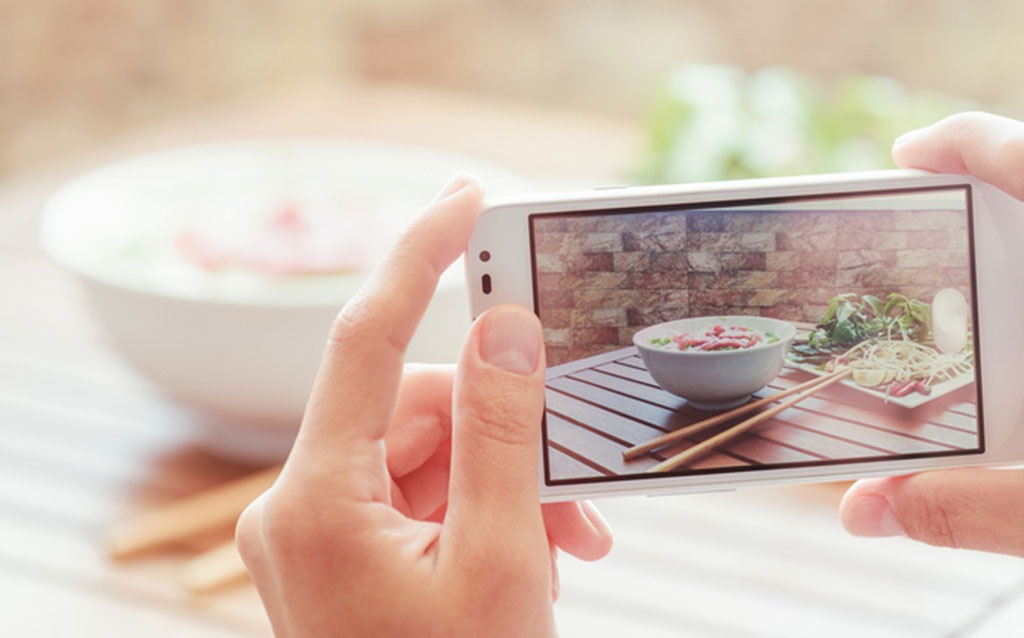 woman taking picture of meal with cellphone