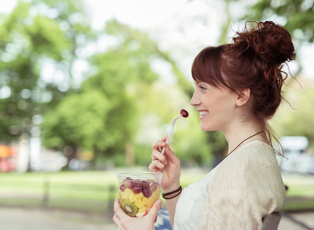 woman eating a grape - best cheat meal on cheat day