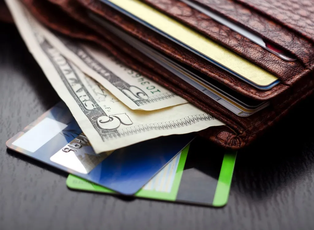 primo piano di un portafoglio con contanti e carte di credito