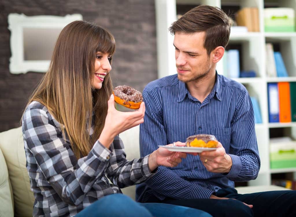 couple eating donuts junk food