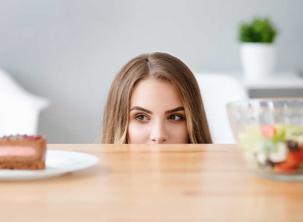 Woman craving junk food over salad - always hungry reasons